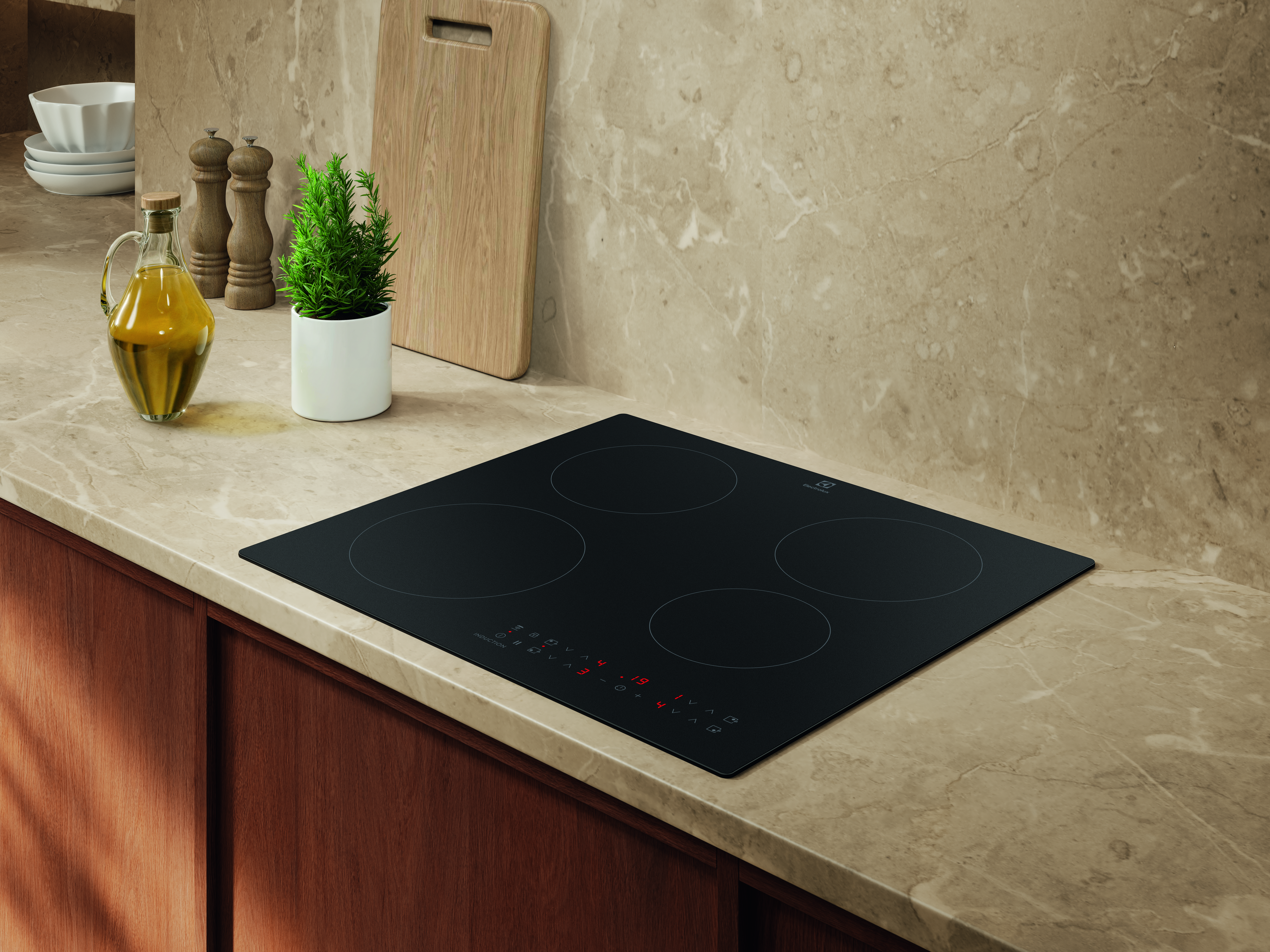 Czarna płyta indukcyjna z czterema strefami gotowania na marmurowym blacie.