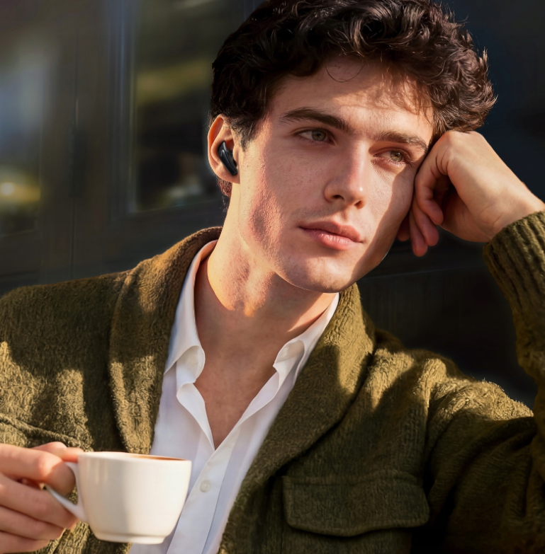 Mężczyzna w słuchawkach trzyma filiżankę kawy, opierając się zamyślony.