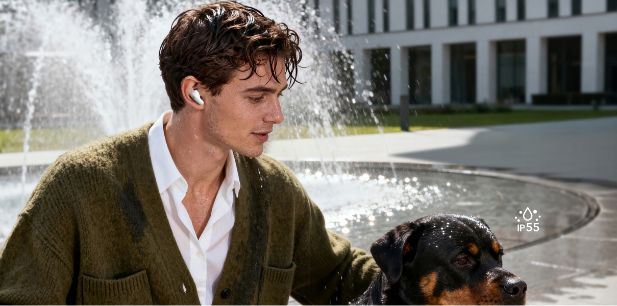 Mężczyzna ze słuchawkami i psem obok fontanny przed budynkiem.