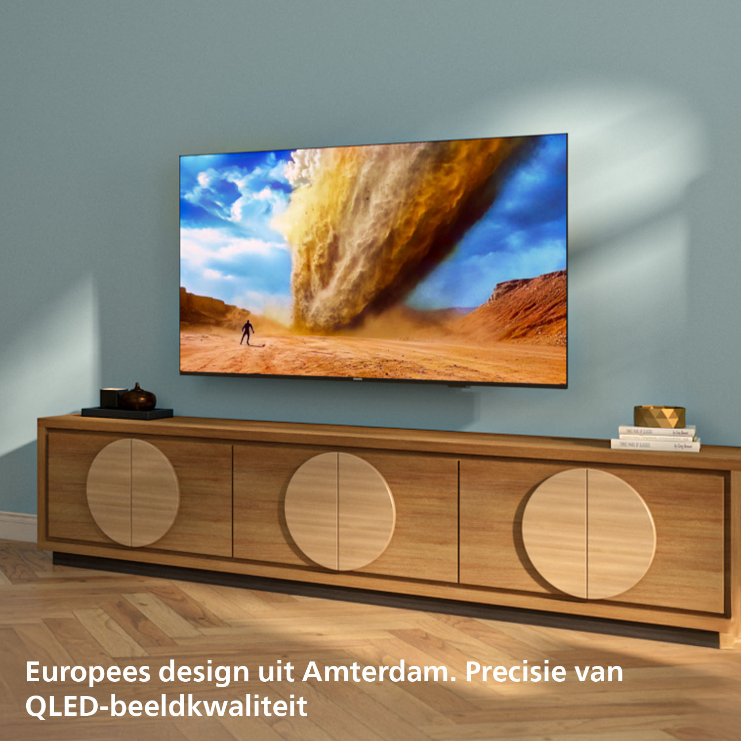 A TV displays a desert tornado above a wooden cabinet. European design.