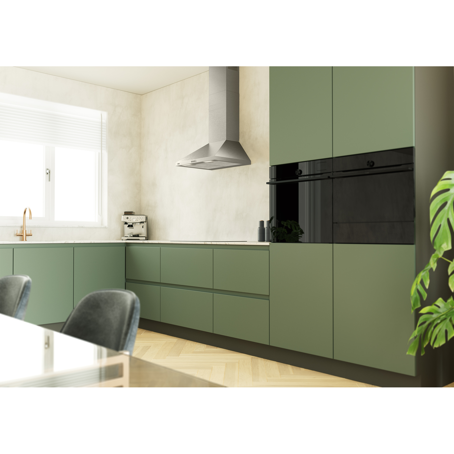 Moderne groene keuken met RVS afzuigkap, inbouwovens en eettafel.