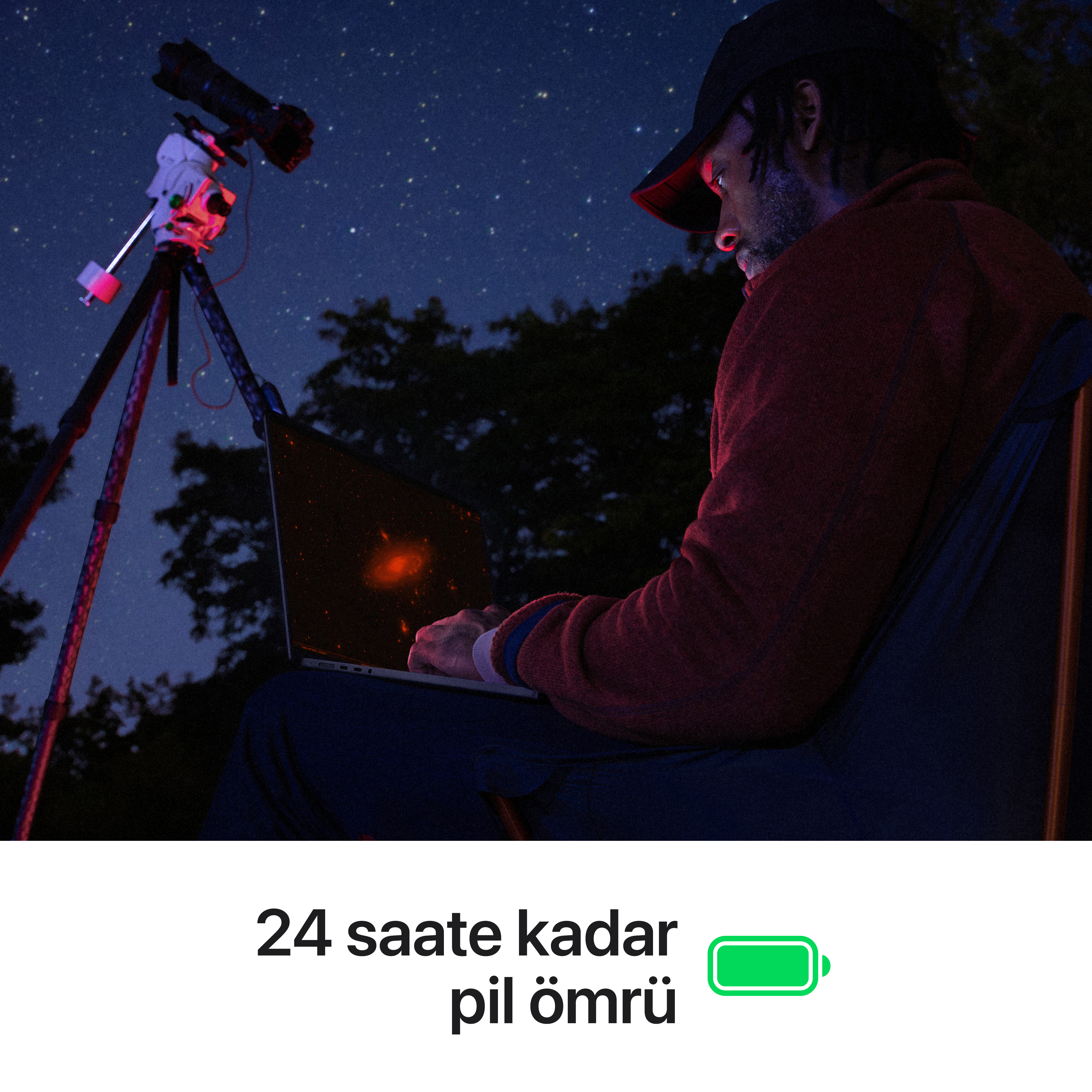 Yıldızlı gökyüzü altında teleskop ve dizüstü bilgisayarlı adam.