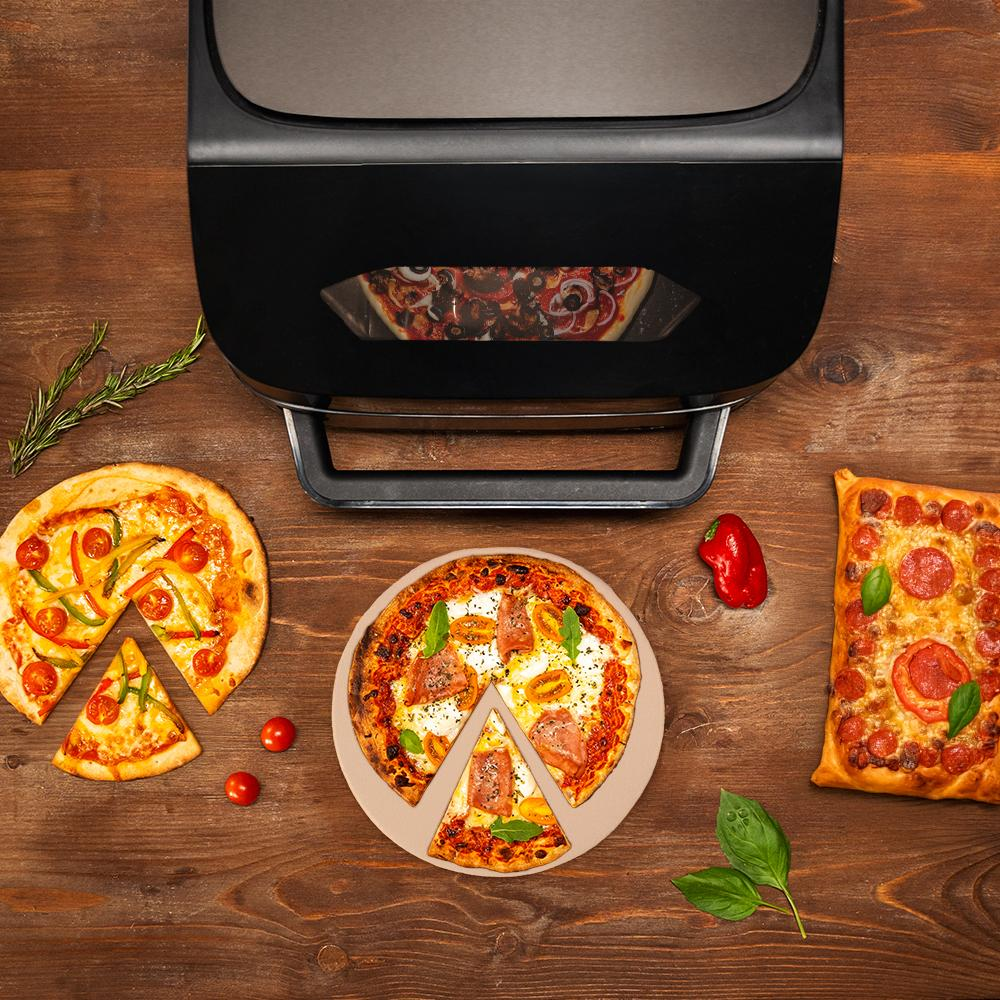 Un horno para pizza con tres pizzas al lado en mesa de madera.