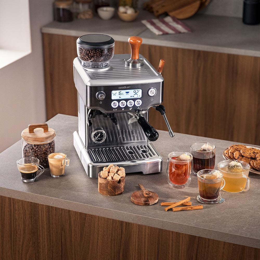 Máquina de espresso con depósito de granos, tazas y galletas.