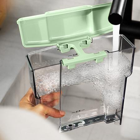 Agua vertiéndose en un recipiente transparente con tapa verde claro.