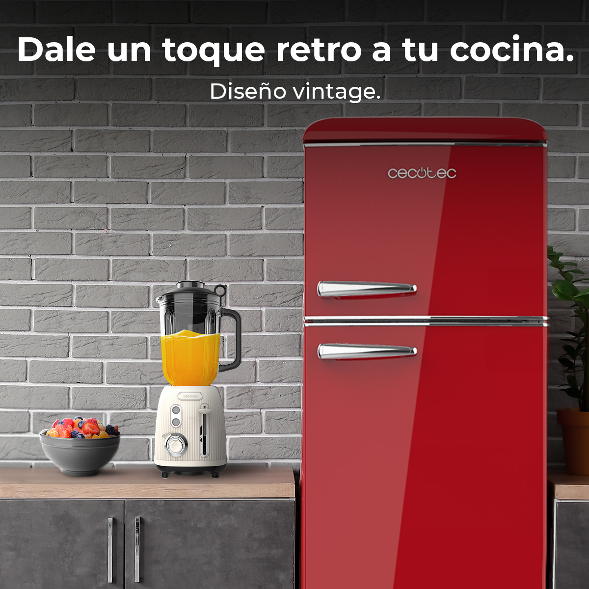 Un refrigerador rojo retro y una licuadora con jugo de naranja sobre una encimera.