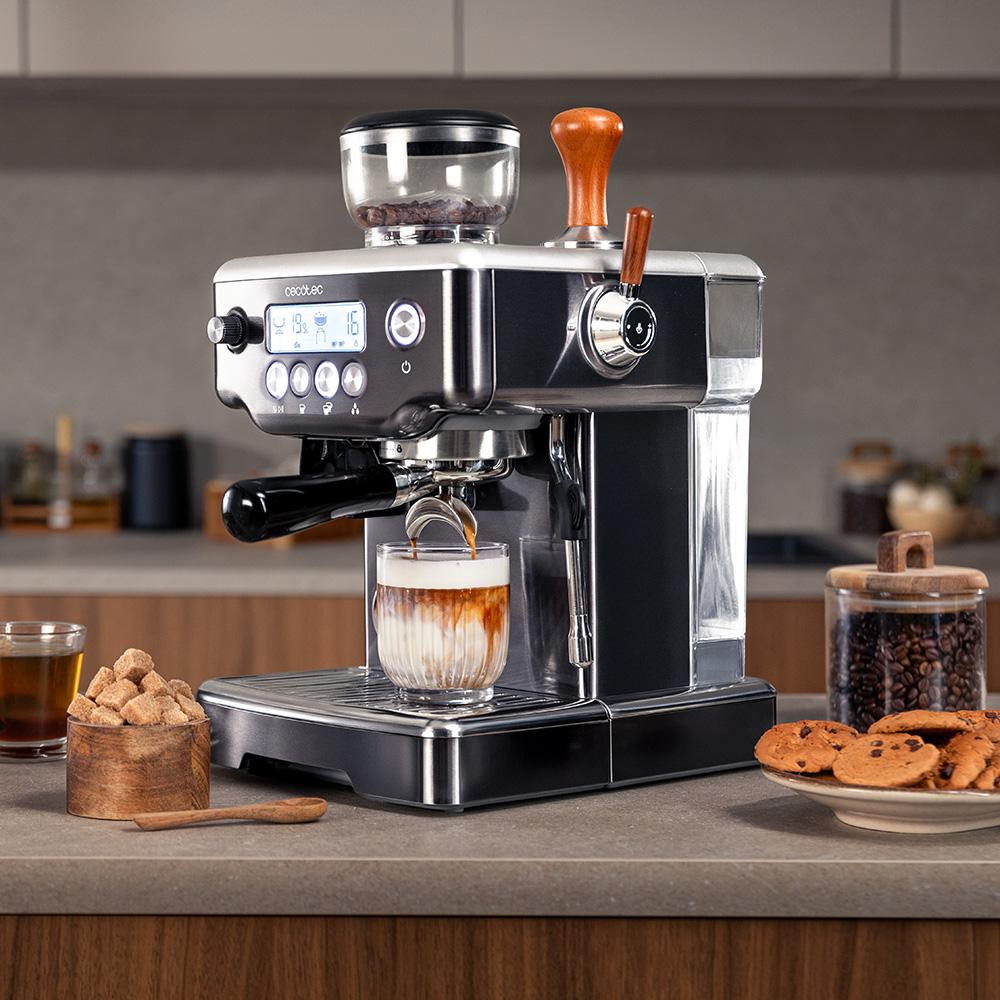 Máquina de café preparando espresso en un vaso, con terrones de azúcar, galletas y granos cerca.