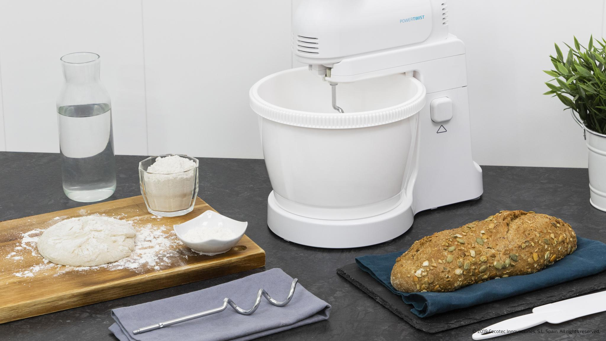Una batidora blanca con ingredientes: masa, harina, agua y pan.