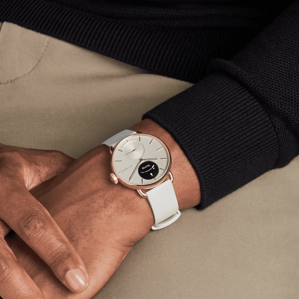 Ein Mann trägt eine Smartwatch mit weißem Armband und roségoldenem Gehäuse.