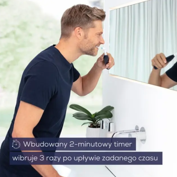 Mężczyzna myje zęby elektryczną szczoteczką w łazience.