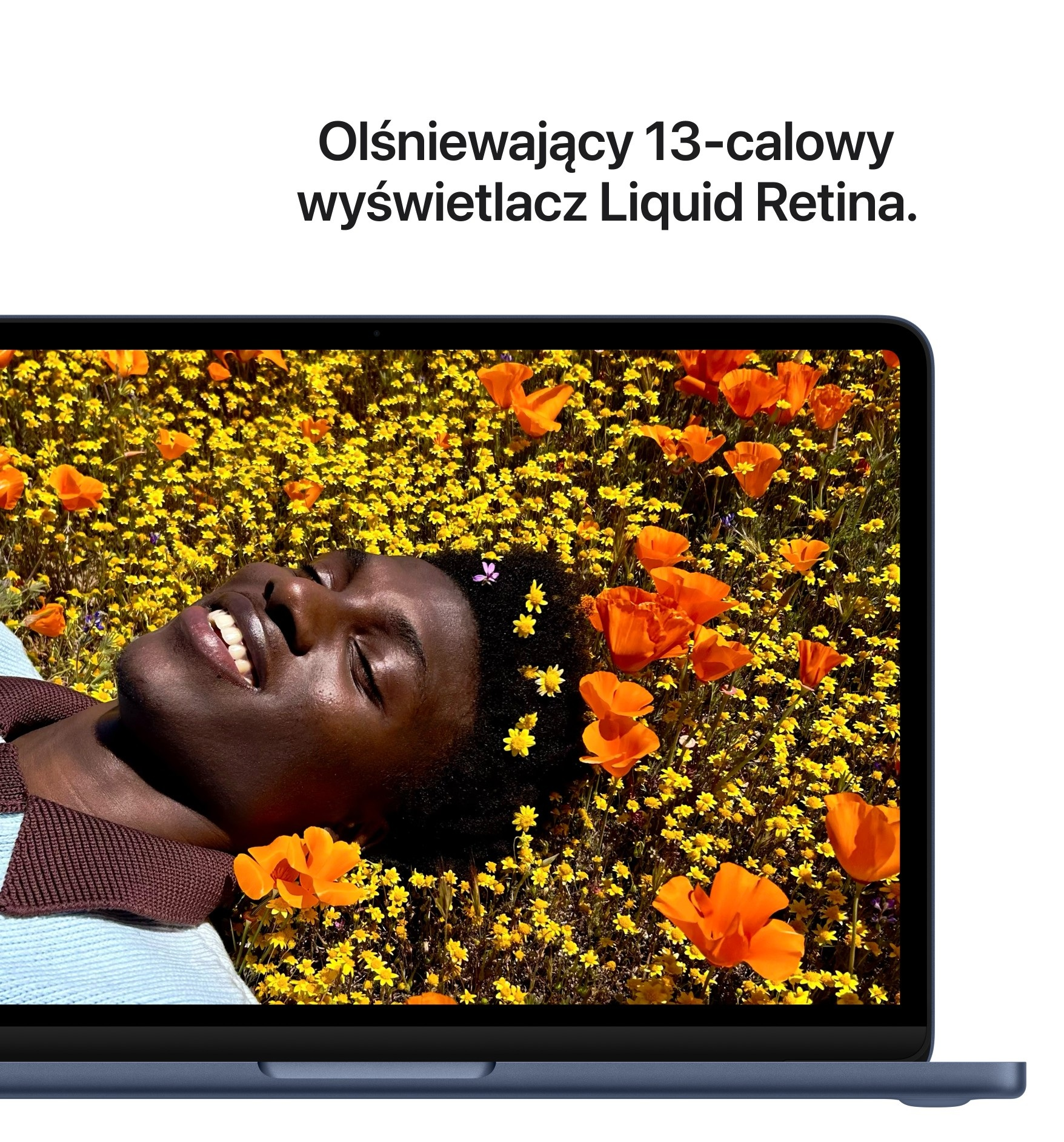 Mężczyzna leży na polu żółtych i pomarańczowych kwiatów, twarzą zwróconą ku słońcu.