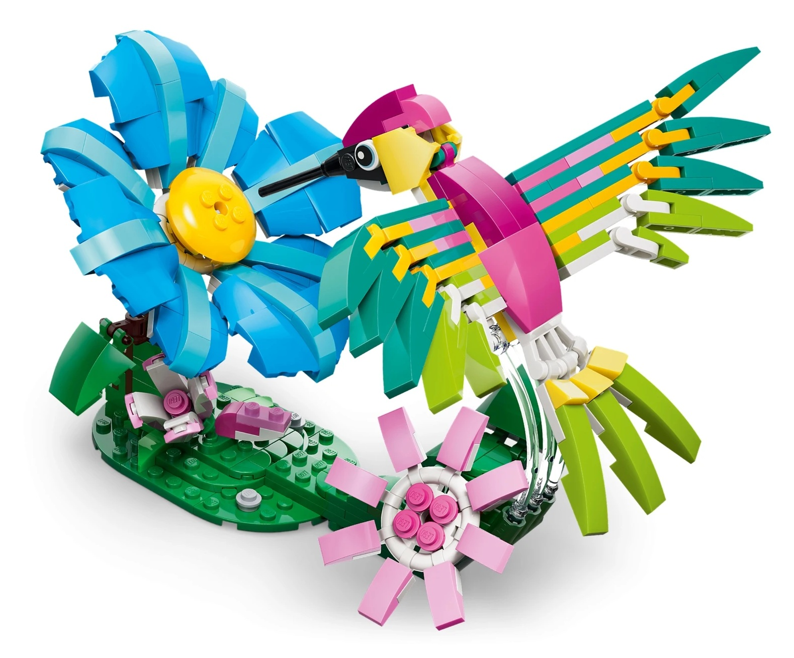 Kolorowy koliber z klocków Lego siedzi na zielonej podstawie z dwoma kwiatami.