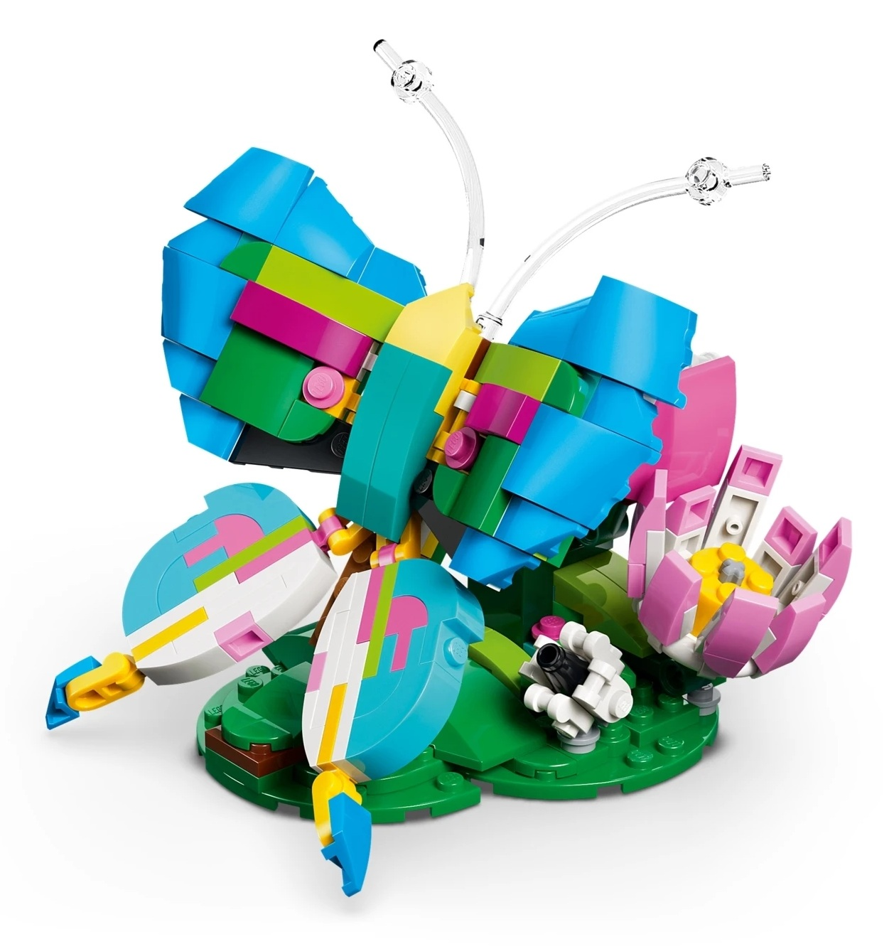 Kolorowy model motyla Lego na zielonej podstawie z kwiatkiem.
