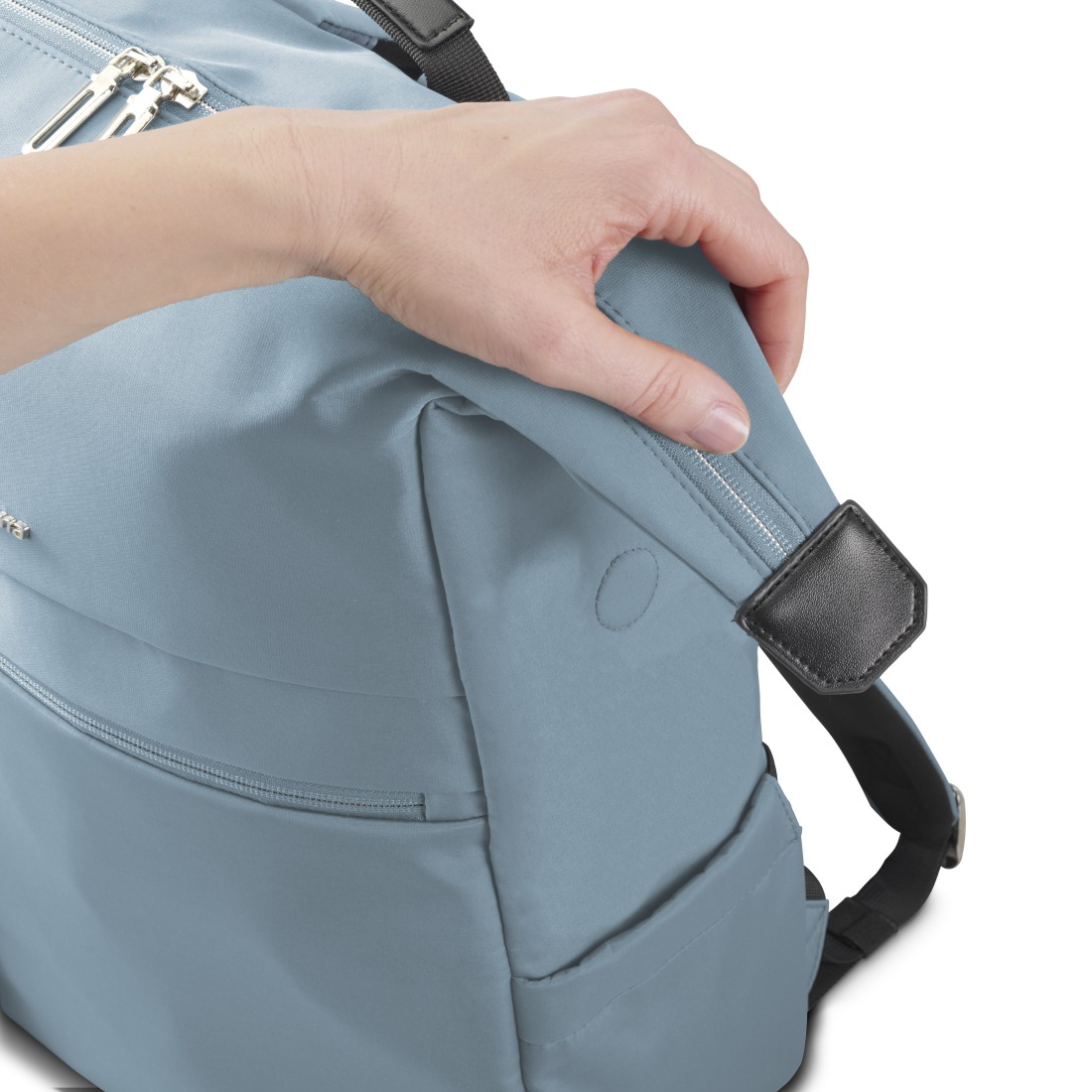 Eine Hand schließt einen Reißverschluss an einer hellblauen Tasche.