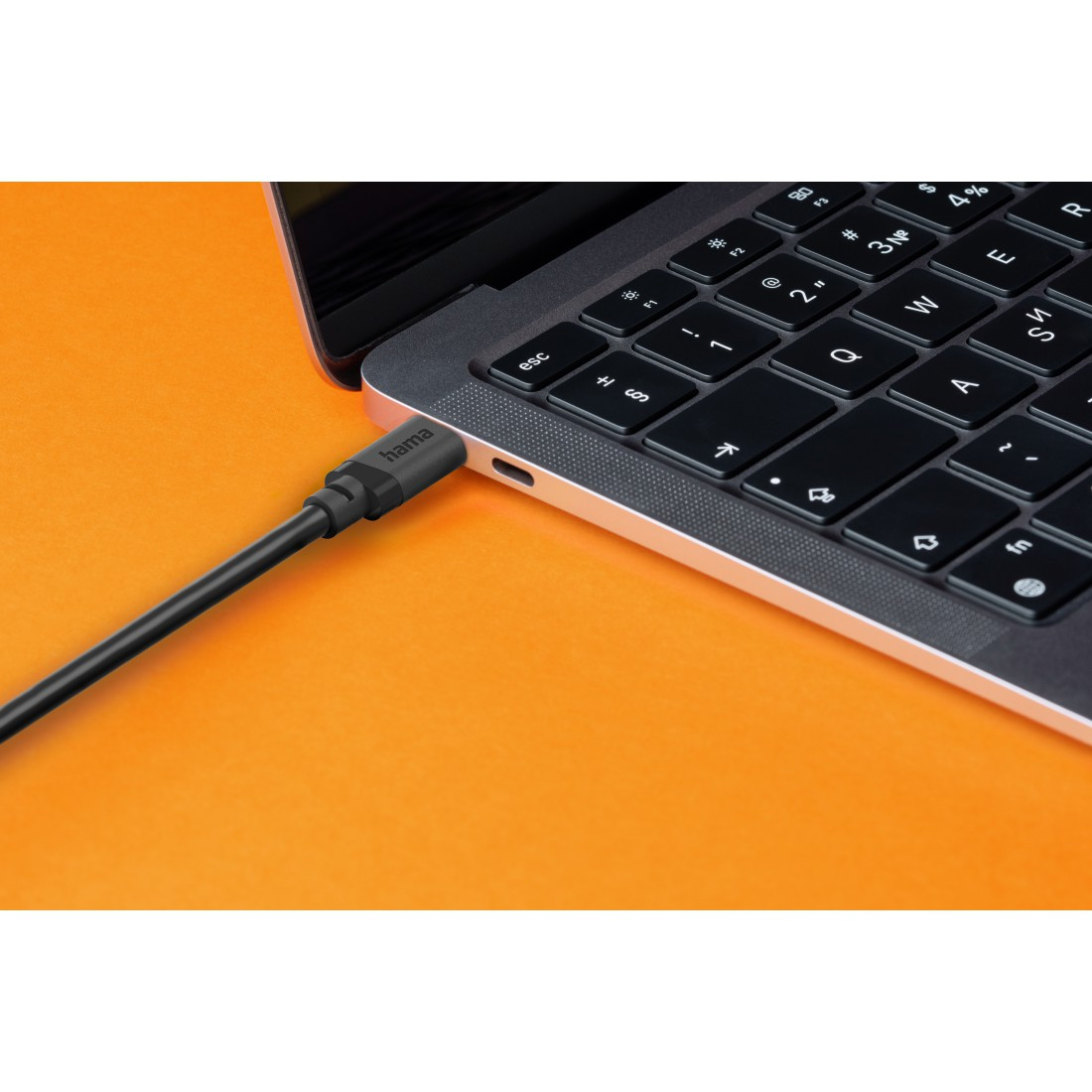 Ein schwarzes USB-Kabel ist in einen Laptop eingesteckt.