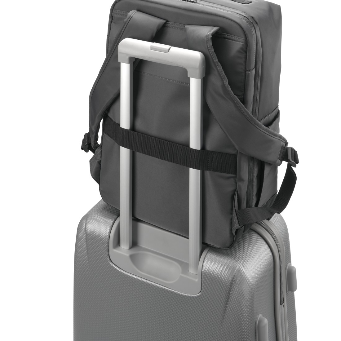 Ein grauer Rucksack sitzt auf einem silbernen Rollkoffer mit ausziehbaren Griffen.