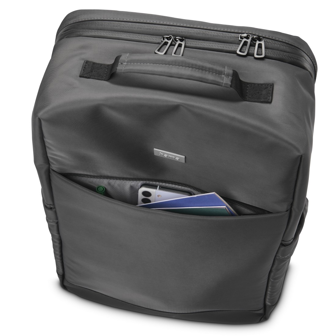 Grauer Rucksack mit offenem Fach, Handy und Broschüren sichtbar.