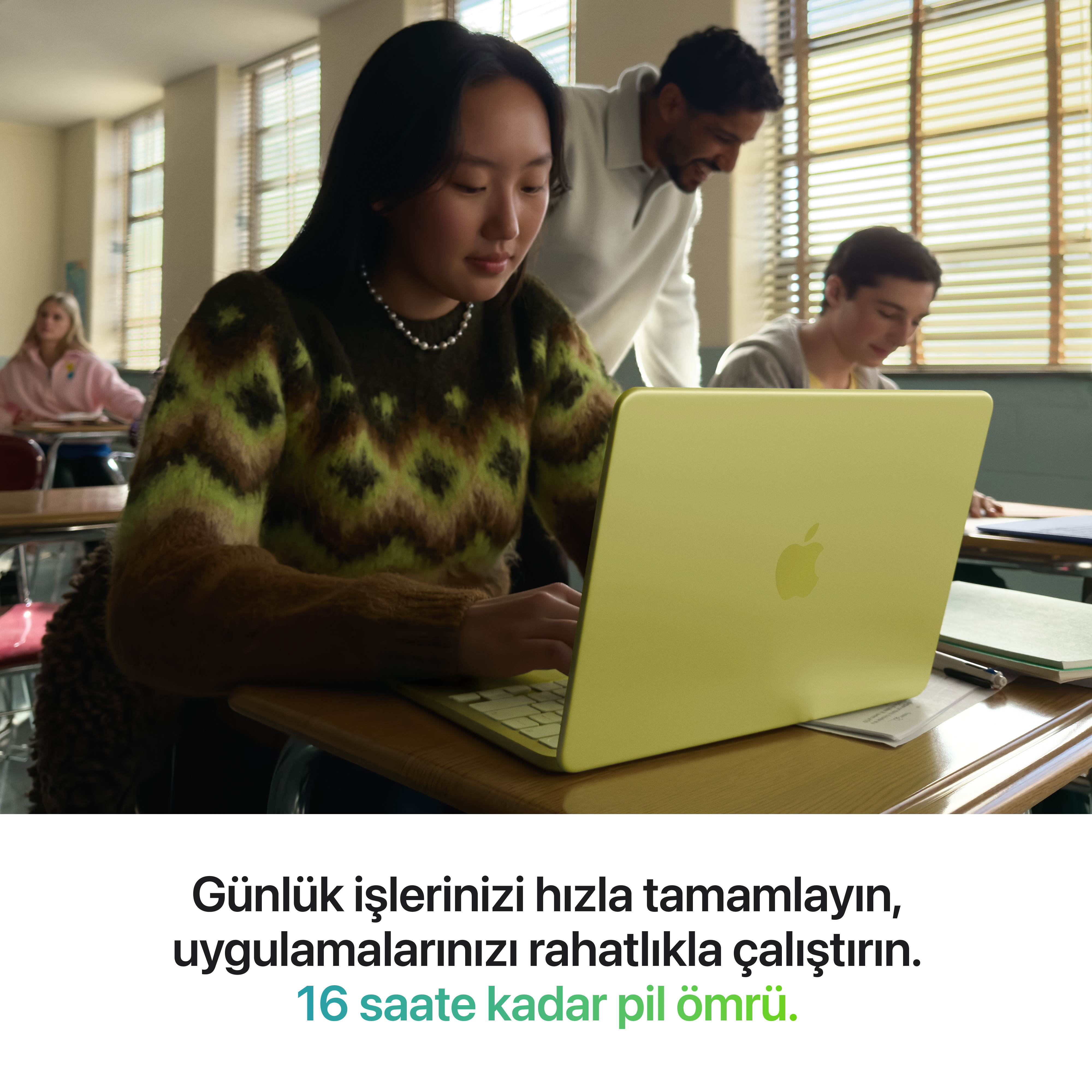Öğrenciler sınıfta sarı bir dizüstü bilgisayarla çalışıyor.