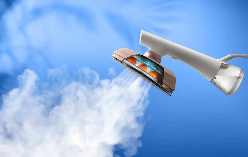 Parownica z odsłoniętym wnętrzem, wyrzucająca parę na tle błękitnego nieba.