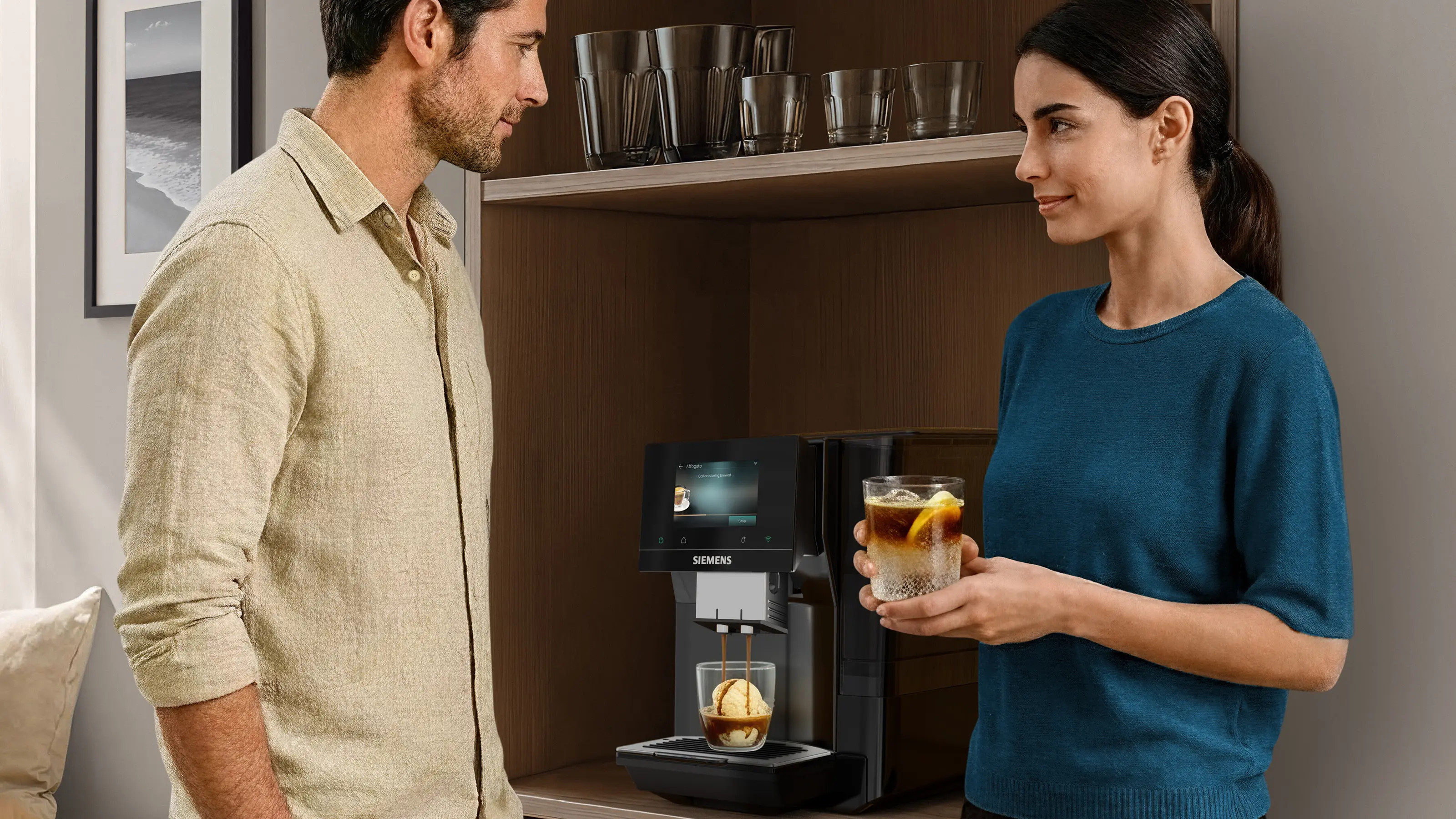 Mężczyzna i kobieta stoją przy ekspresie do kawy. Kawa jest przygotowywana.