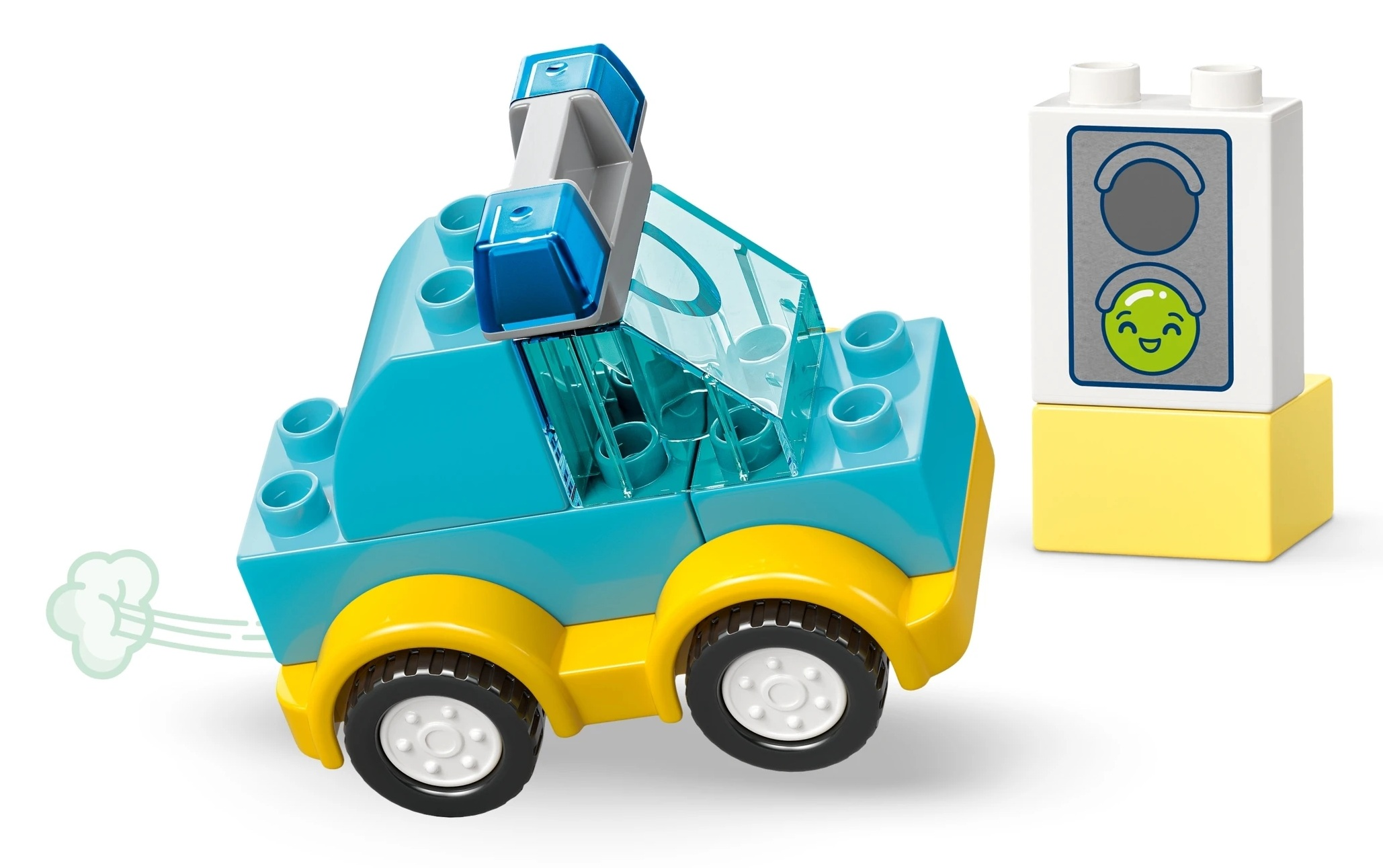 Niebieski samochód Lego z żółtymi kołami jedzie obok zabawki sygnalizacji świetlnej.