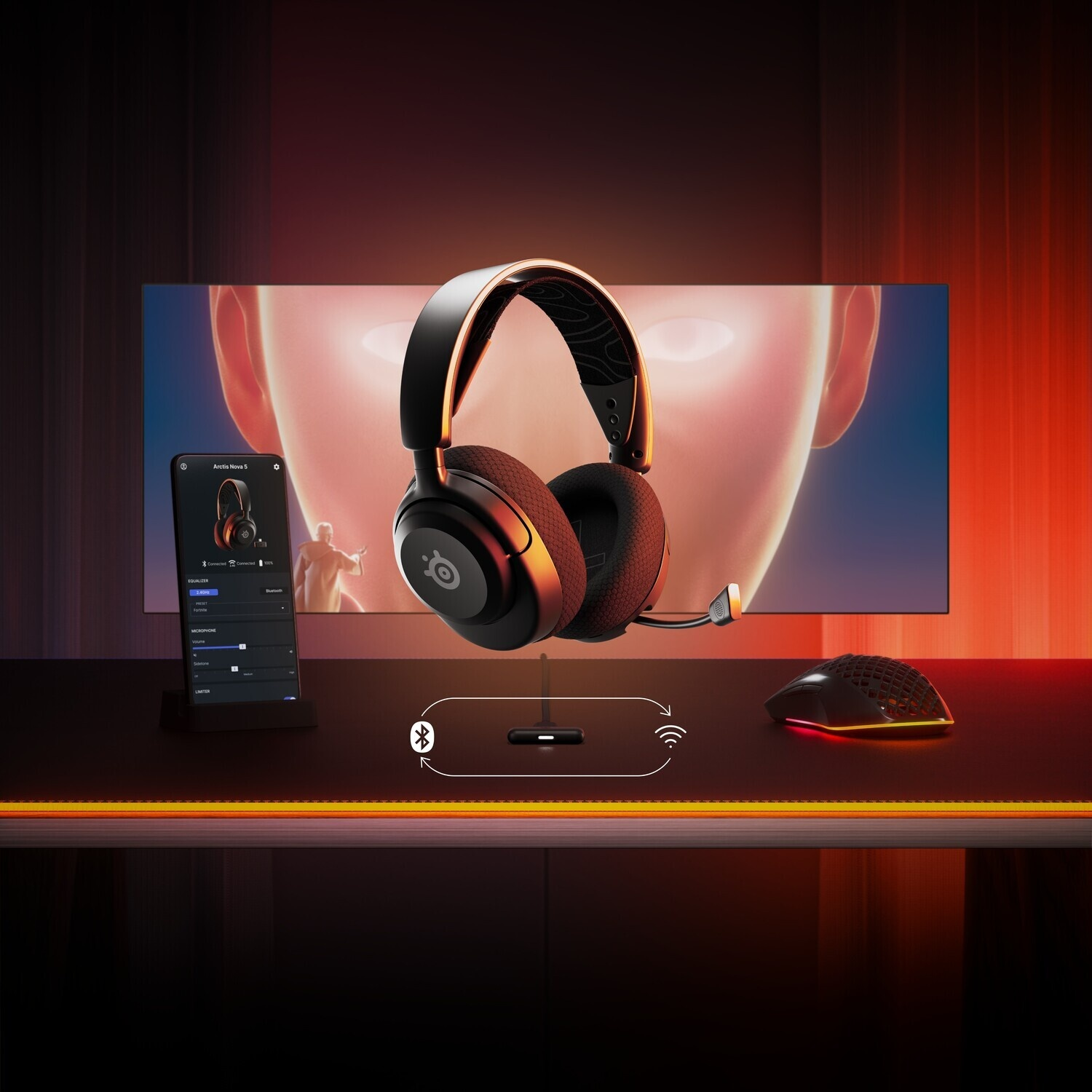 Un auricolare nero con accenti arancioni e un mouse su una scrivania.