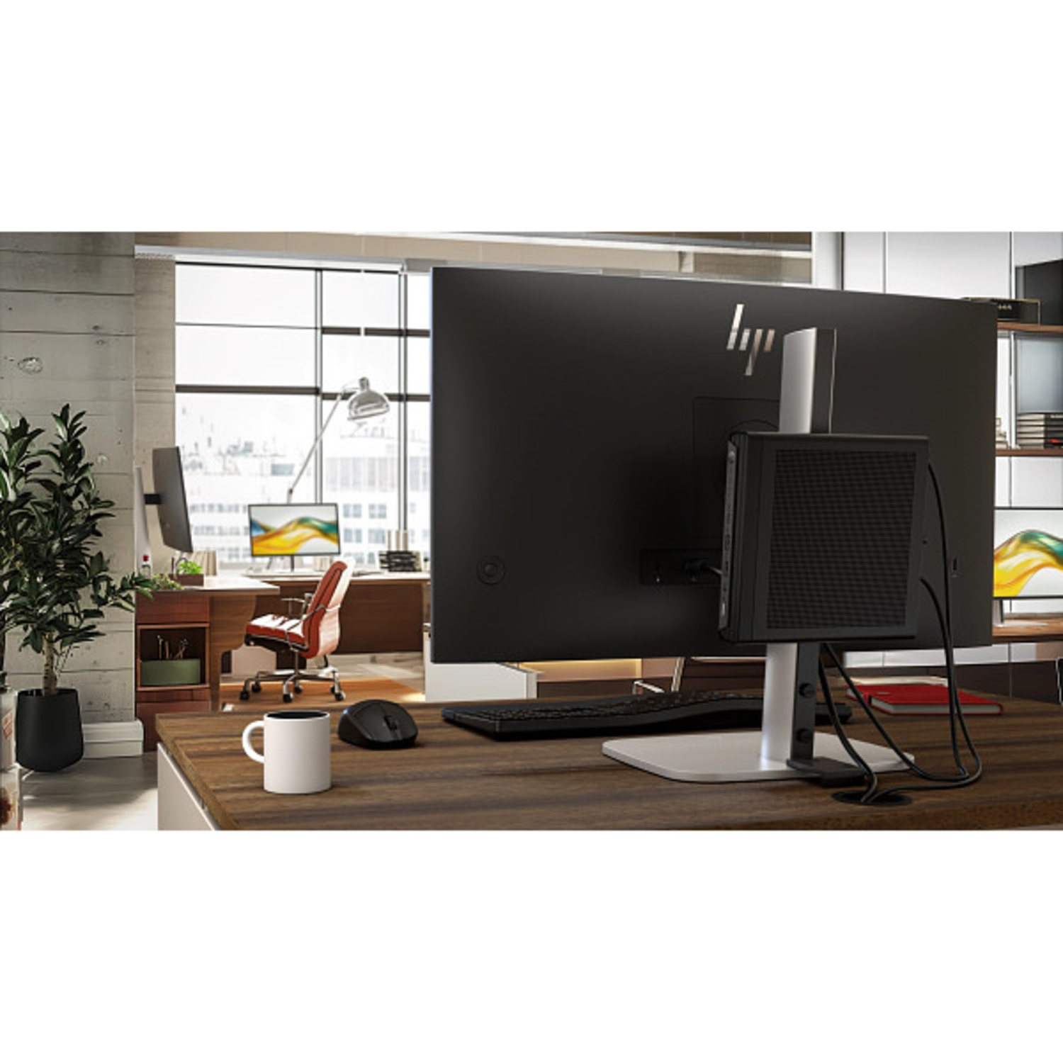 Een bureau met monitor, toetsenbord, muis en mok in een modern kantoor.