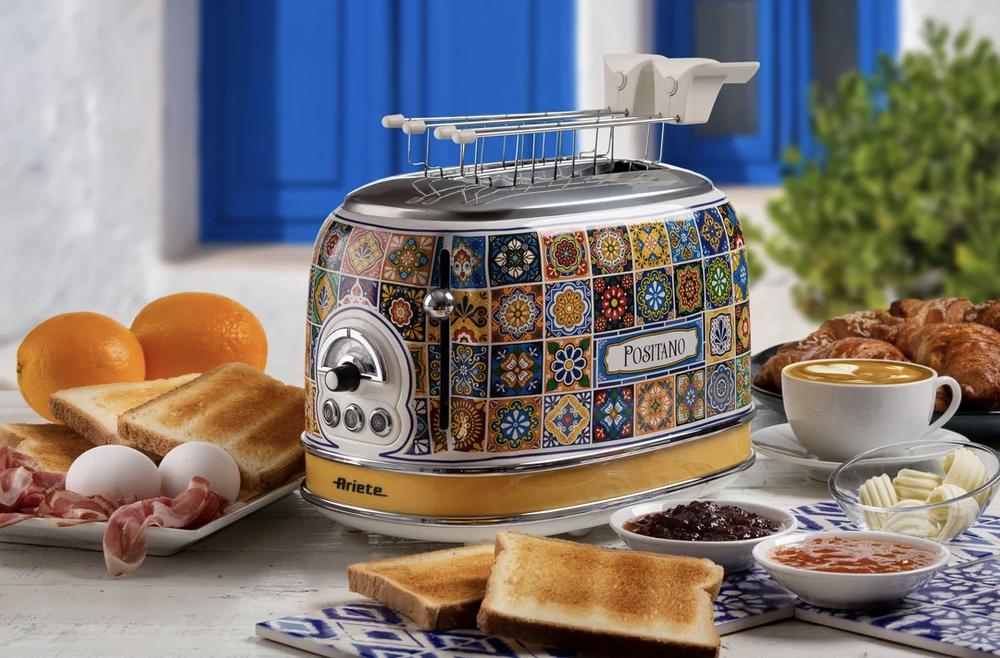 Színes kenyérpirító kávéscsészével, croissanttal, narancsokkal, tojásokkal.