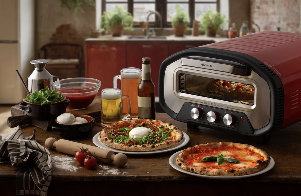 Piros pizza sütő, két pizzával és sörrel egy faasztalon.