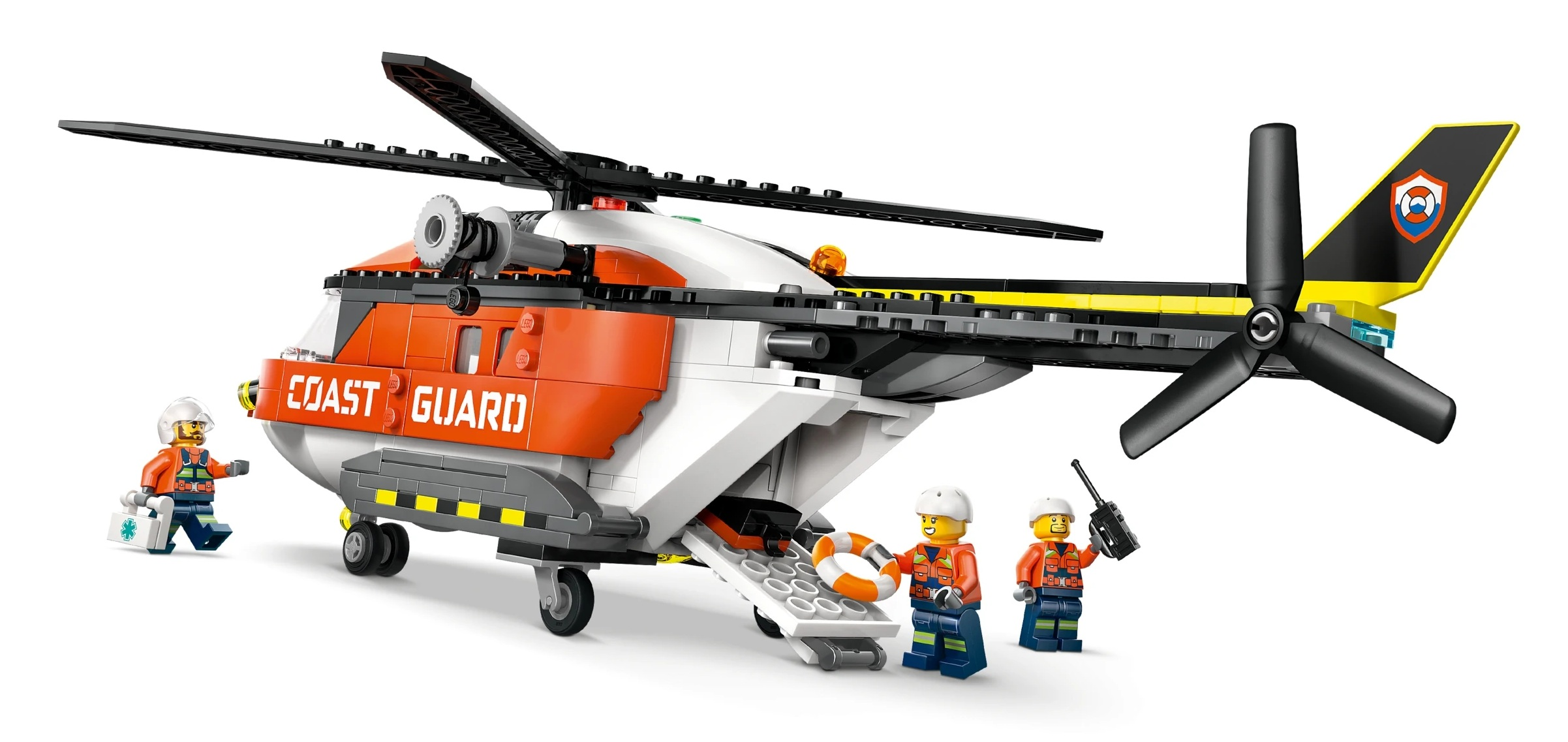 Pomarańczowo-biały helikopter Straży Przybrzeżnej z trzema figurkami Lego na białym tle.
