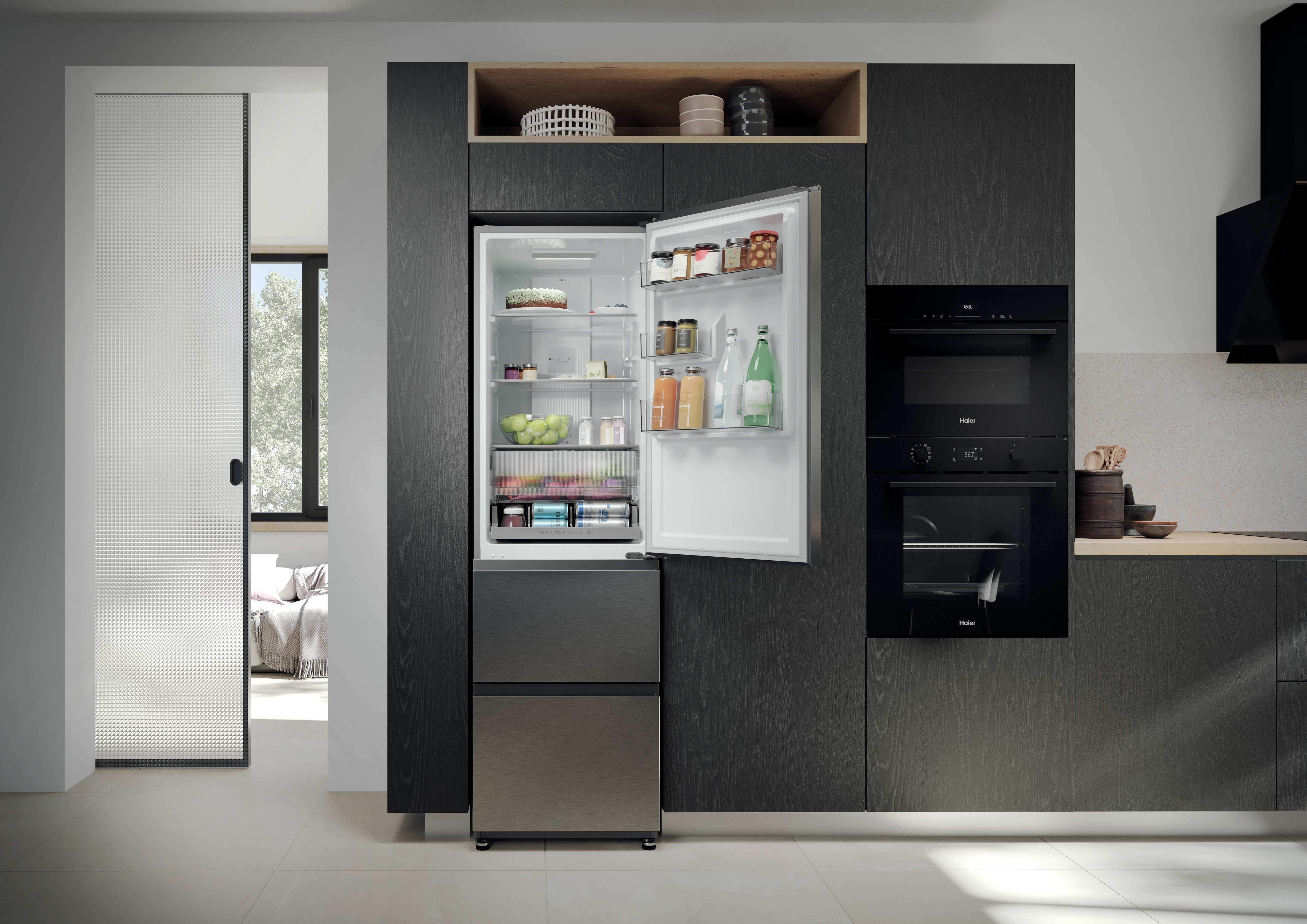 Moderne Küche mit offenem Kühlschrank, Backöfen und Holzakzenten.