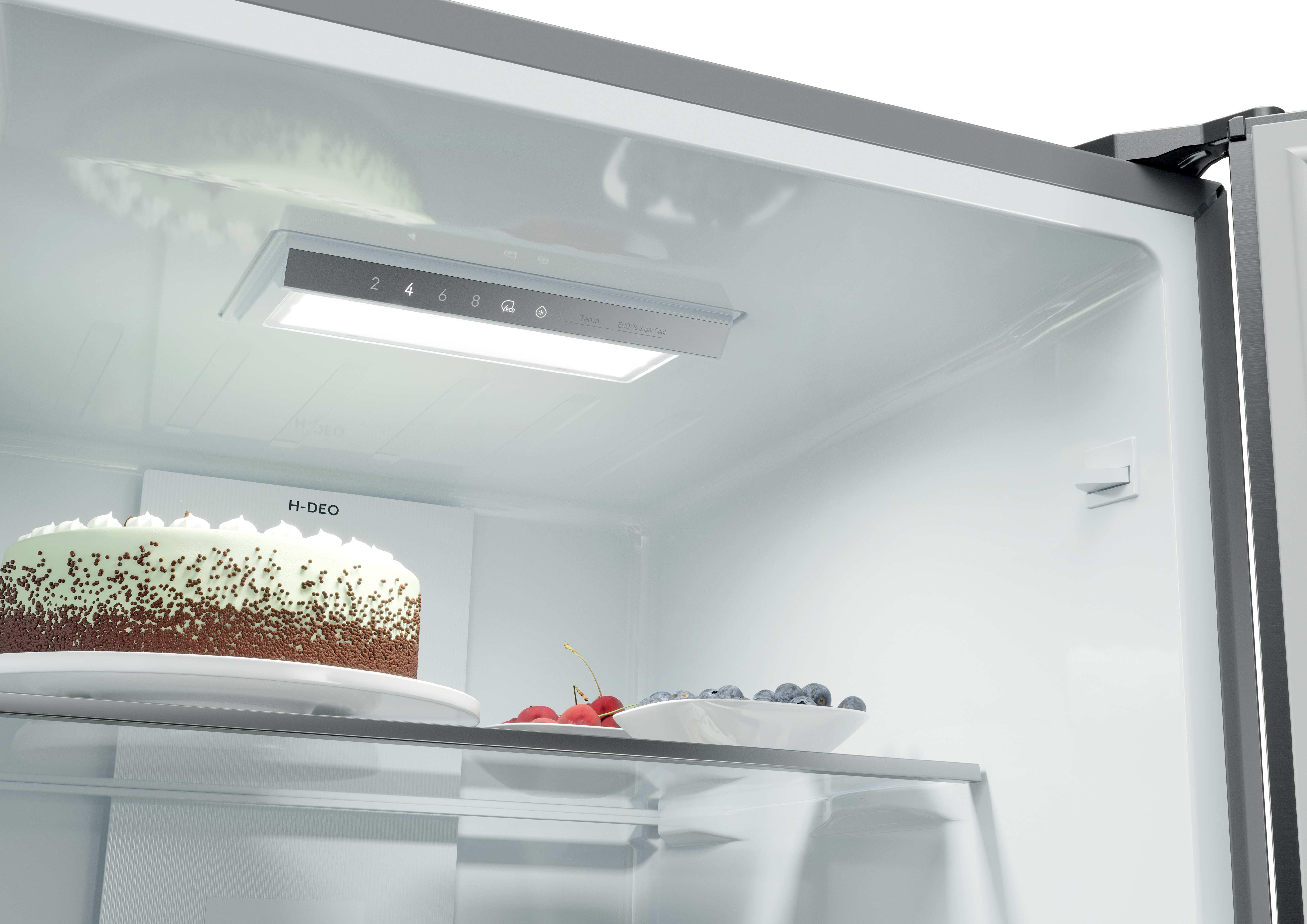 Ein Kuchen mit Schokostreuseln und eine Schale mit Beeren im Kühlschrank.