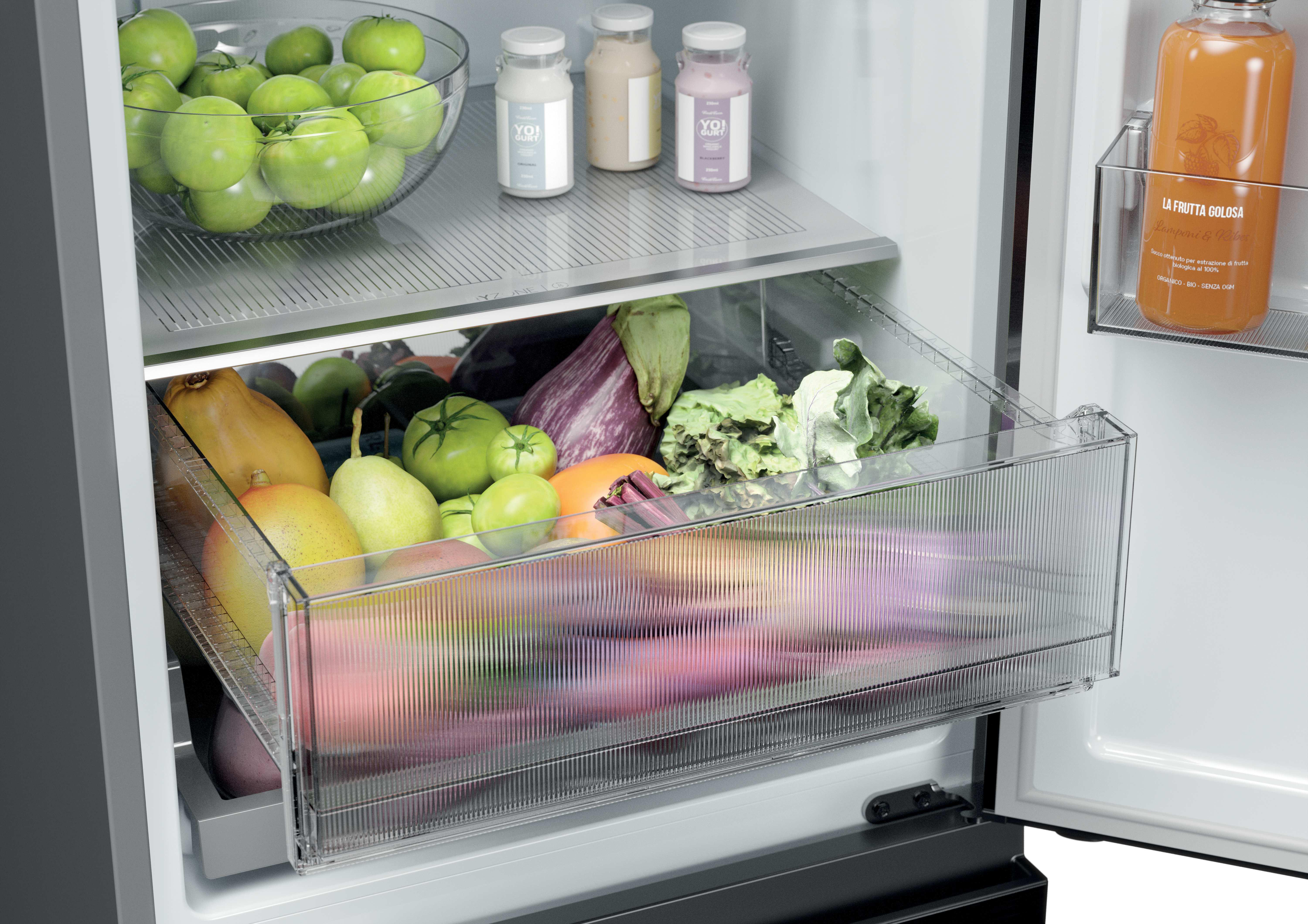 Kühlschrank mit grünen Tomaten, Joghurt, Gemüse und Saftflasche.