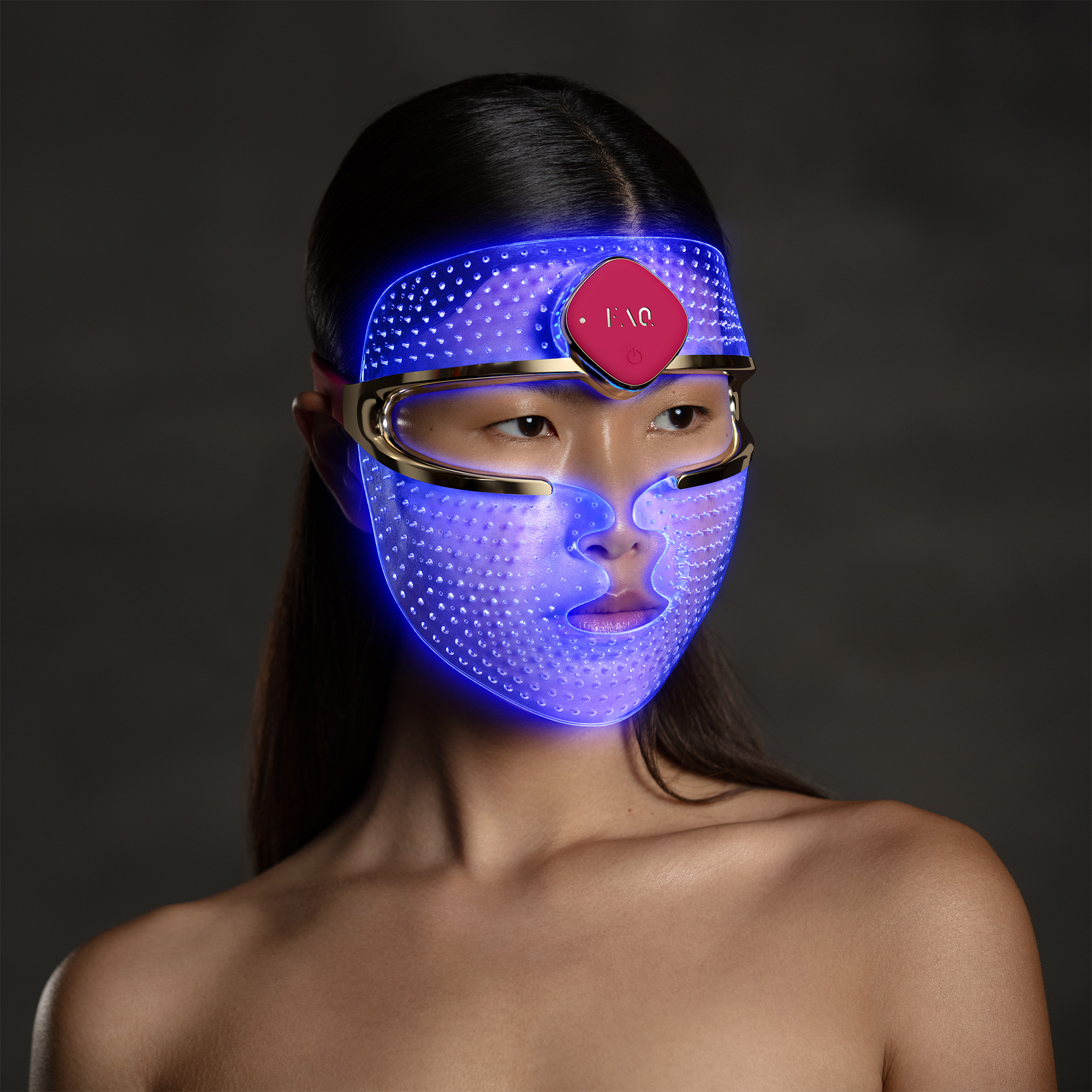 Mujer con mascarilla facial LED azul y marco dorado.