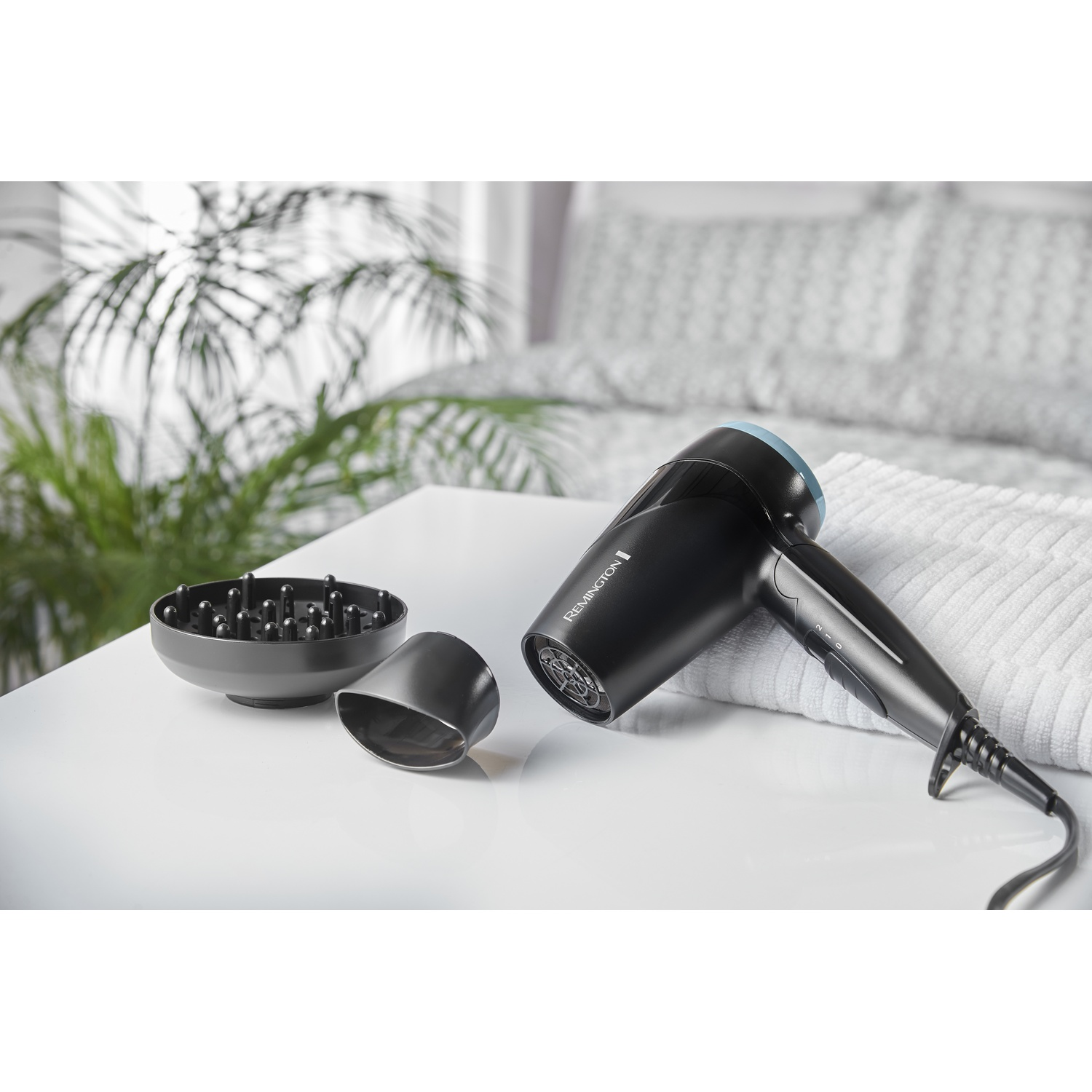 Asciugacapelli nero con diffusore e concentratore su tavolo bianco.