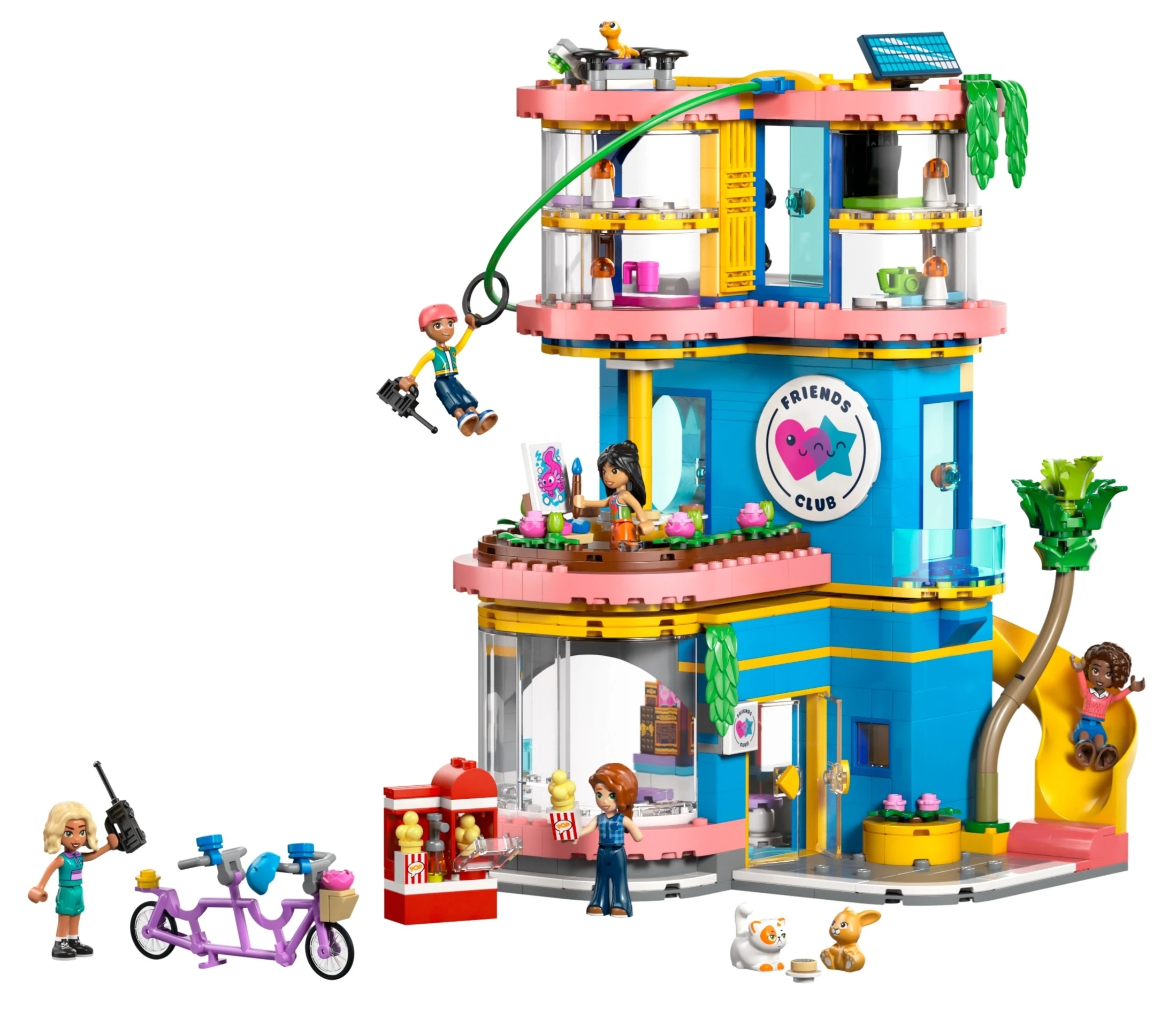Kolorowy budynek Lego Friends Club z figurkami, rowerem, stoiskiem z popcornem i zwierzętami.