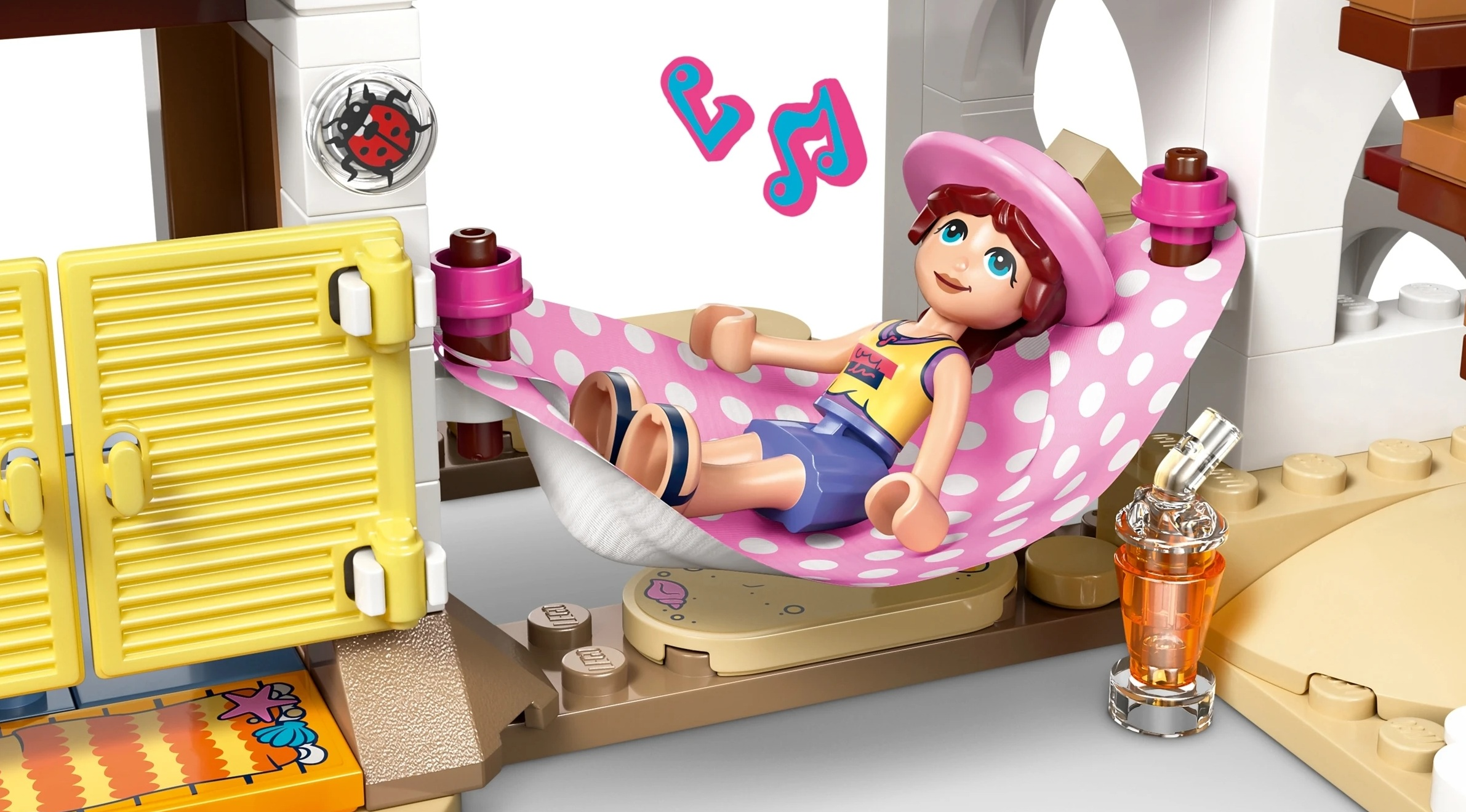 Dziewczynka w różowym kapeluszu relaksuje się w hamaku w kropki.