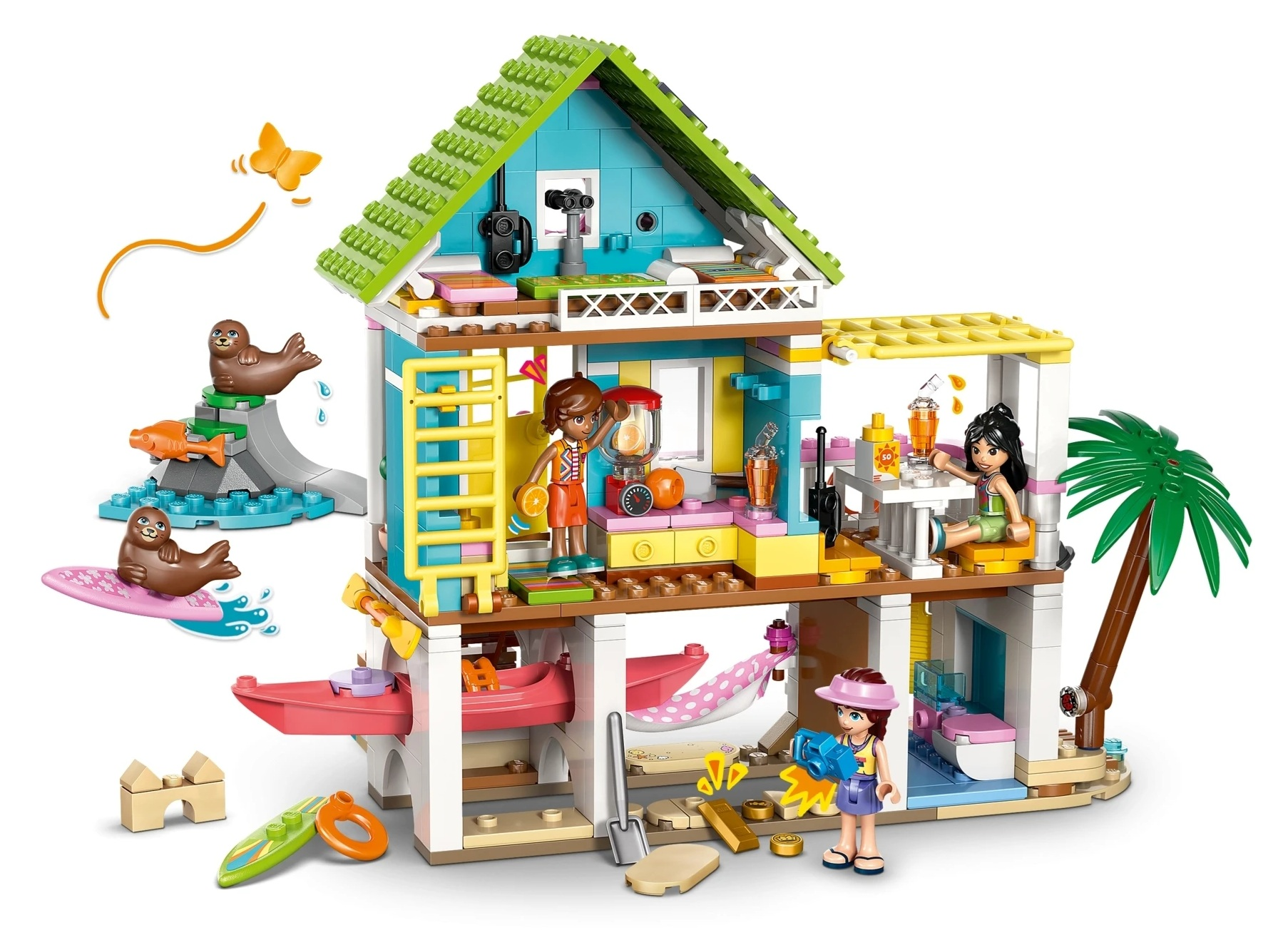 Kolorowy dom plażowy Lego z postaciami, fokami, deską surfingową i palmą.