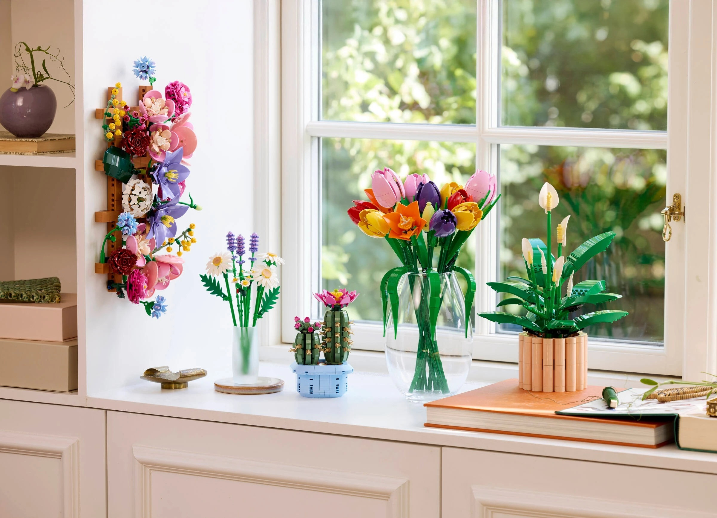 Kwiaty Lego na parapecie: tulipany, orchidee, kaktus i roślina doniczkowa.