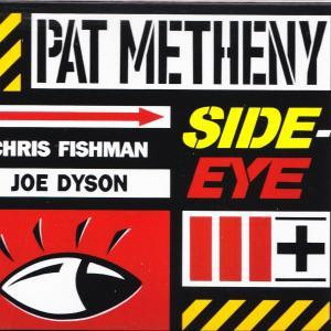 Pat Metheny Side Eye album borító szemmel és sárga-fekete figyelmeztető csíkokkal.