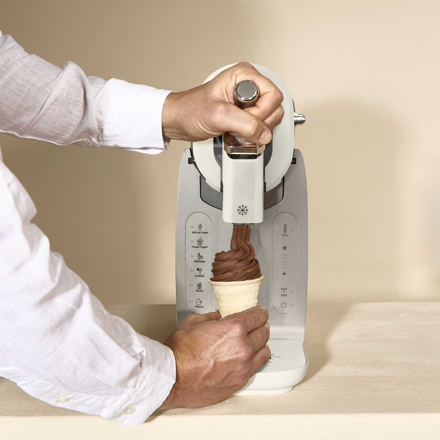 Chocolate ice cream being dispensed into a cone from a machine.