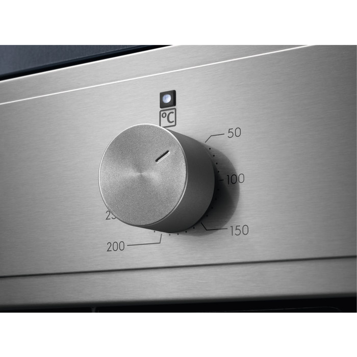 Un dial plateado en un horno de acero inoxidable con ajustes de temperatura.