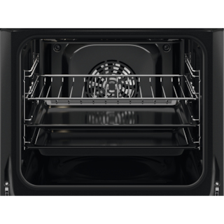 Vista interior de un horno negro con tres rejillas y ventilador al fondo.