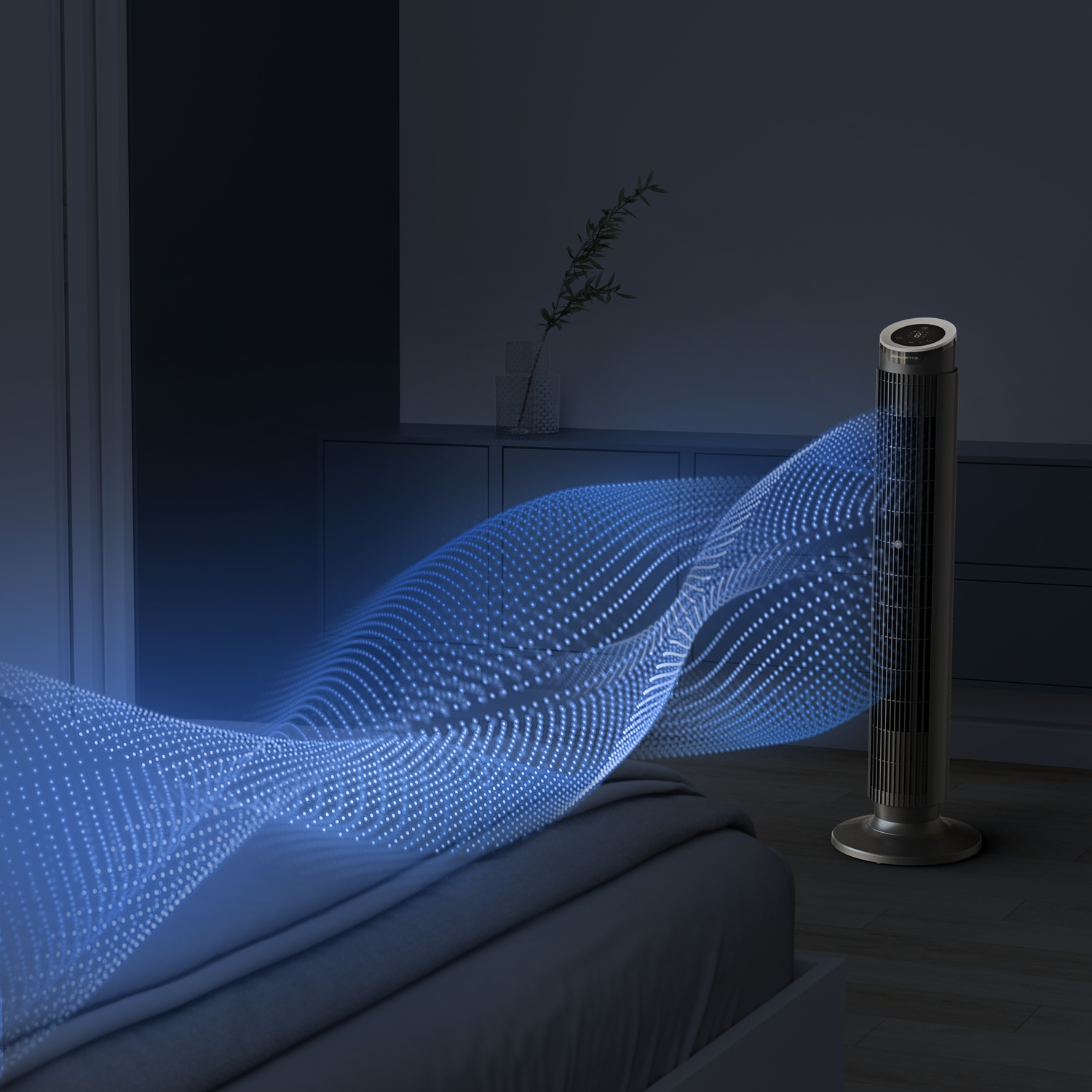 Un ventilateur tour diffuse des particules d'air bleues sur un lit dans une pièce sombre.