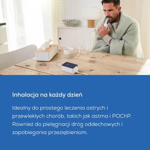 Mężczyzna siedzi przy stole i używa inhalatora.