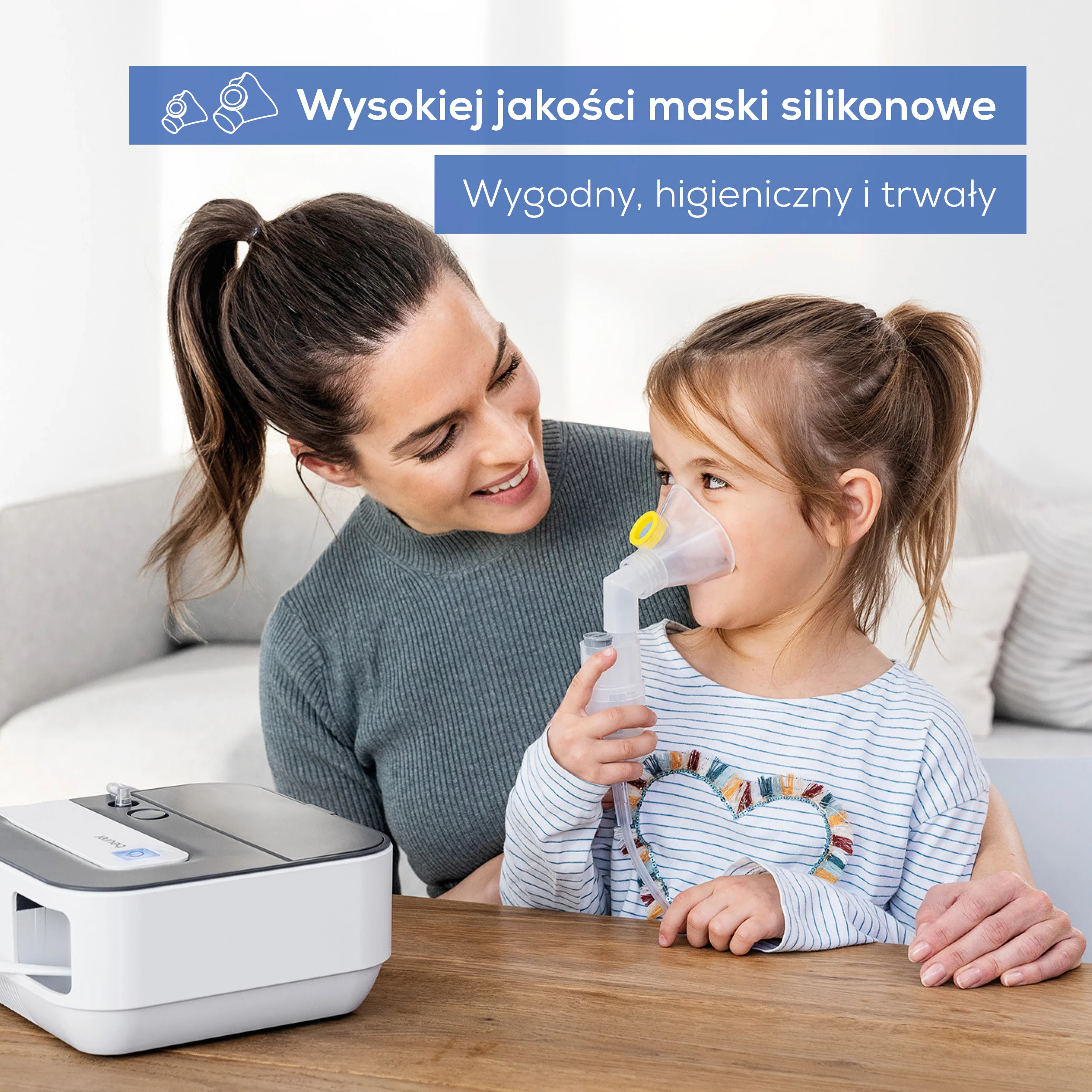 Kobieta uśmiecha się do dziecka w masce inhalacyjnej. Obok stoi nebulizator.