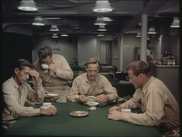 Vier Männer in Uniform sitzen an einem Tisch und trinken.
