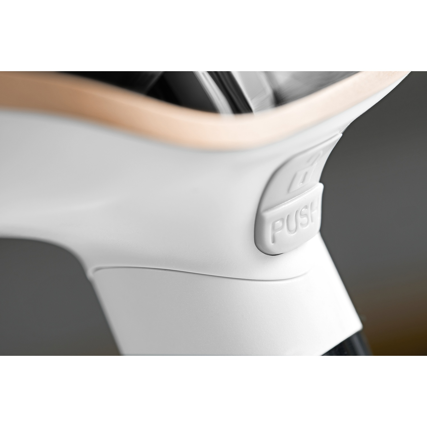 Un pulsante bianco con etichetta "PUSH" su un dispositivo elegante con finiture in legno.