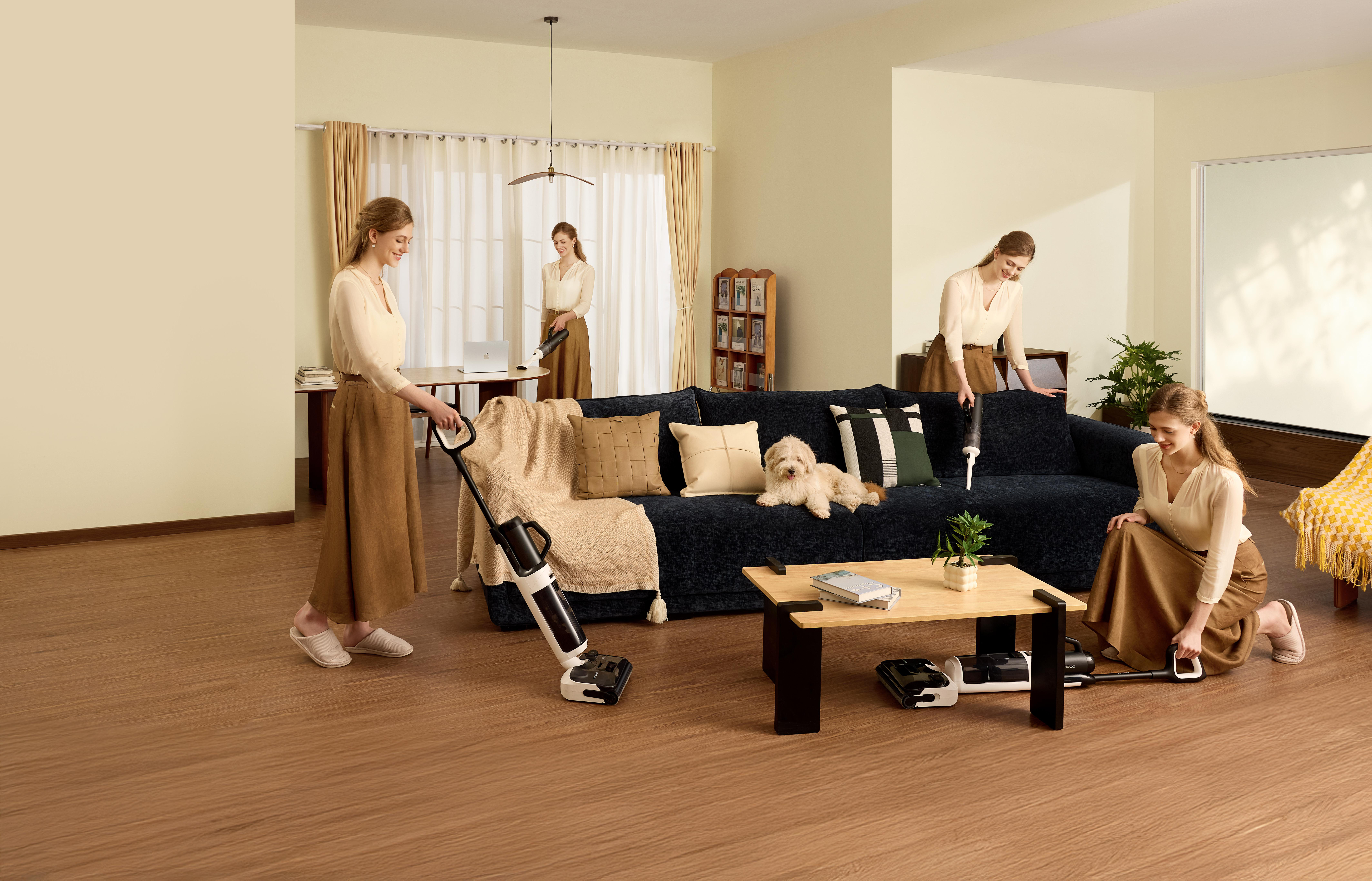 Eine Frau reinigt mit einem Staubsauger ein Wohnzimmer mit Hund und Sofa.