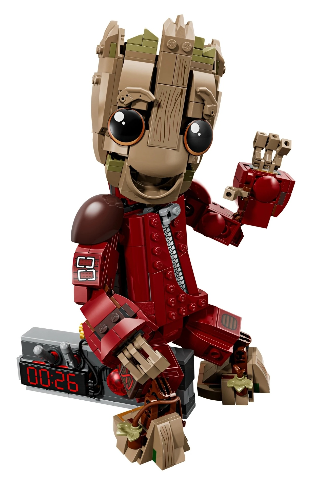 Groot z klocków Lego siedzi na budziku. Nosi czerwony kombinezon z zamkiem.